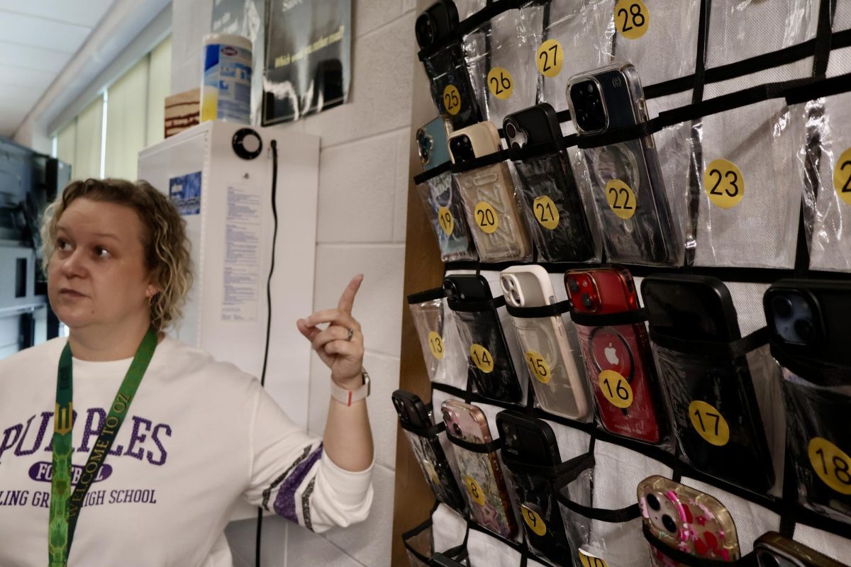 Chemistry teacher Marti Watson stands in front of the phone pouches she uses to enforce the new phone rule.